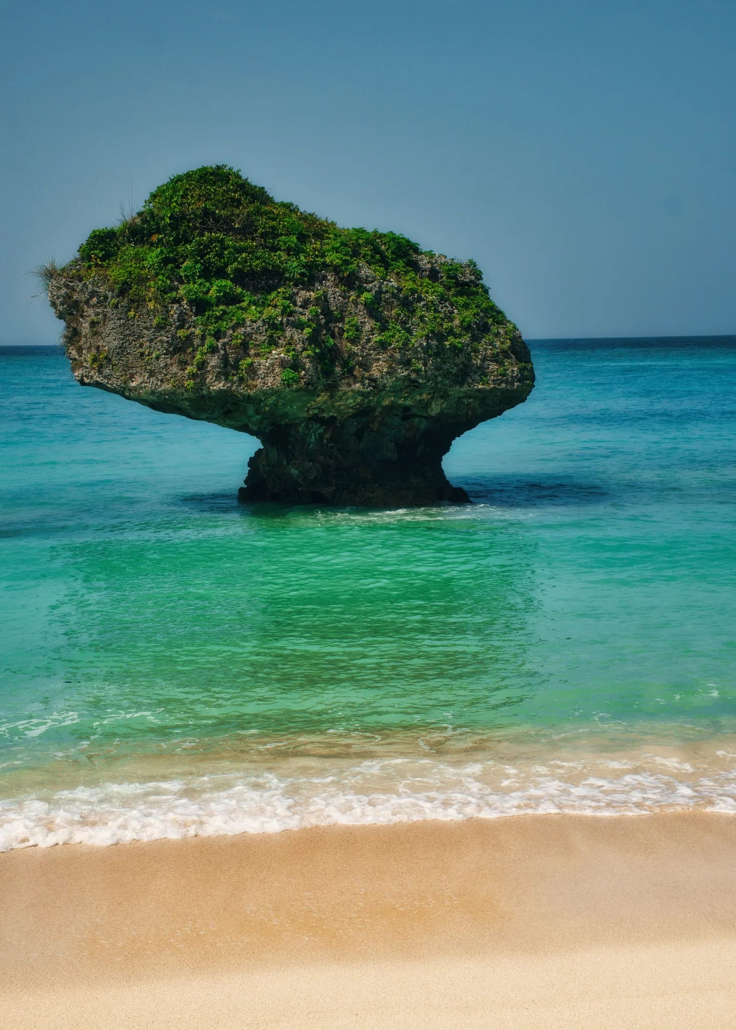 Turquoise water and a rock on the beach in Okinawa