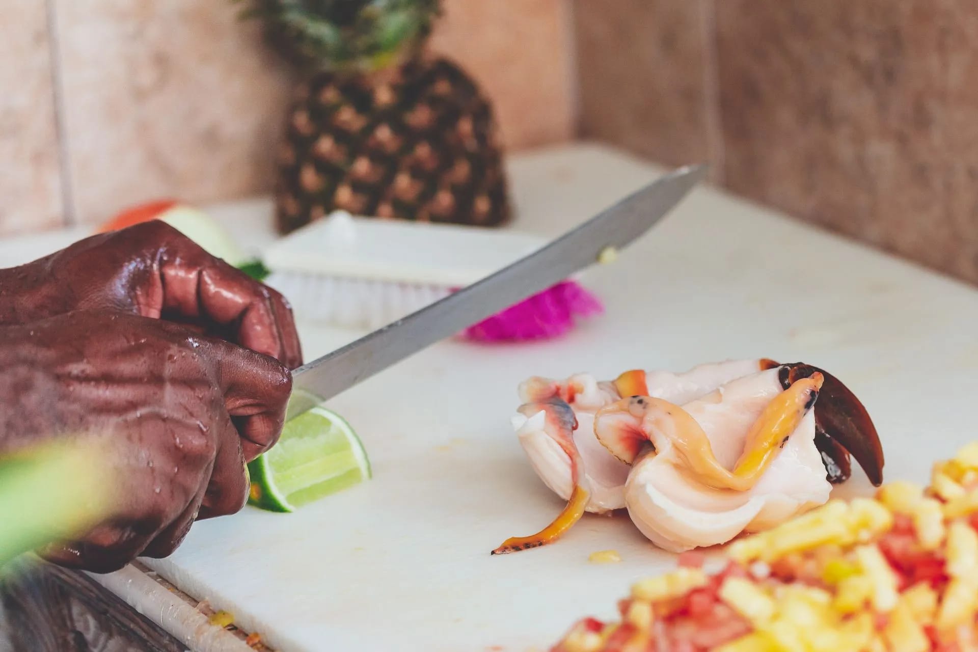 Hands cutting conch for a conch salad