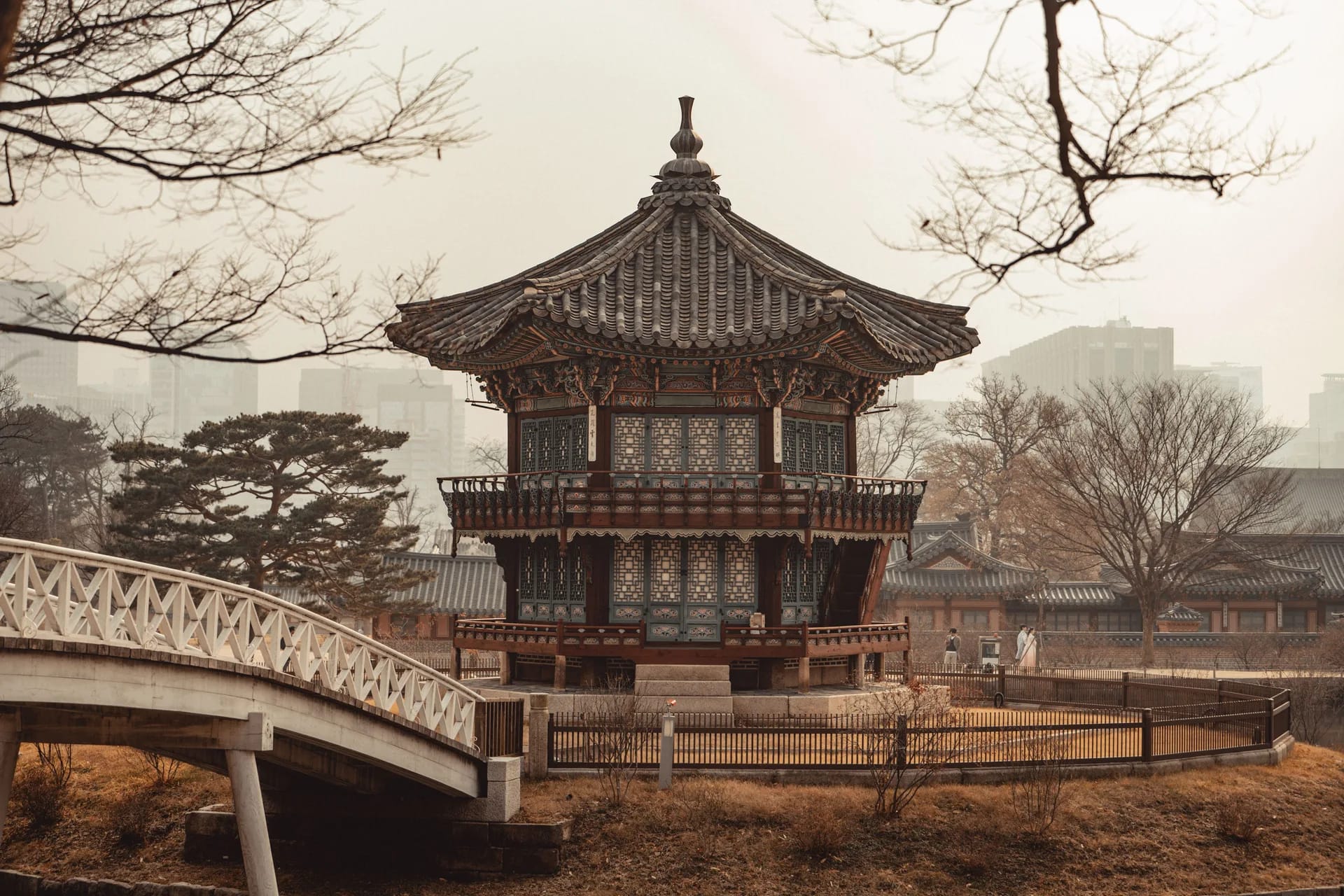 Hyangwonjeong Pavilion in the winter haze, the city behind it