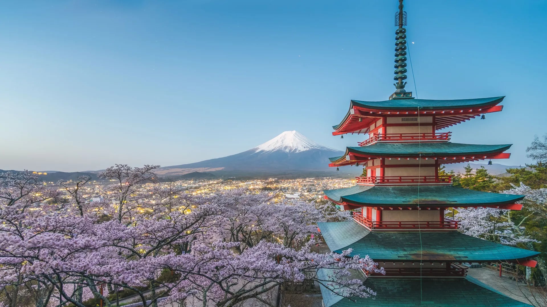 A pagoda in front of Mount Fuji at dusk