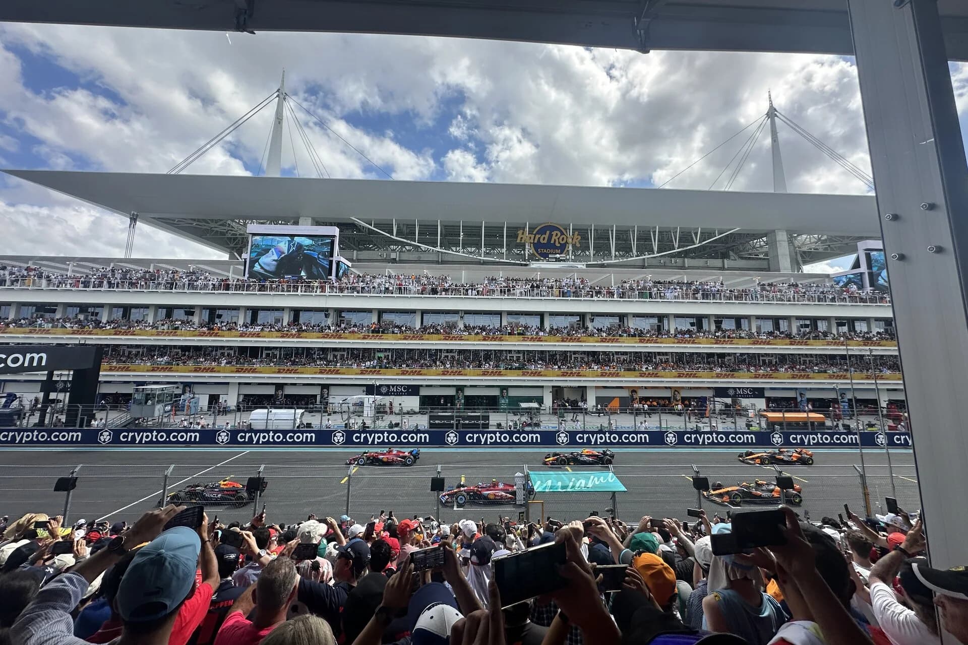 Cars on the main straight in front of packed grandstands in Miami Gardens