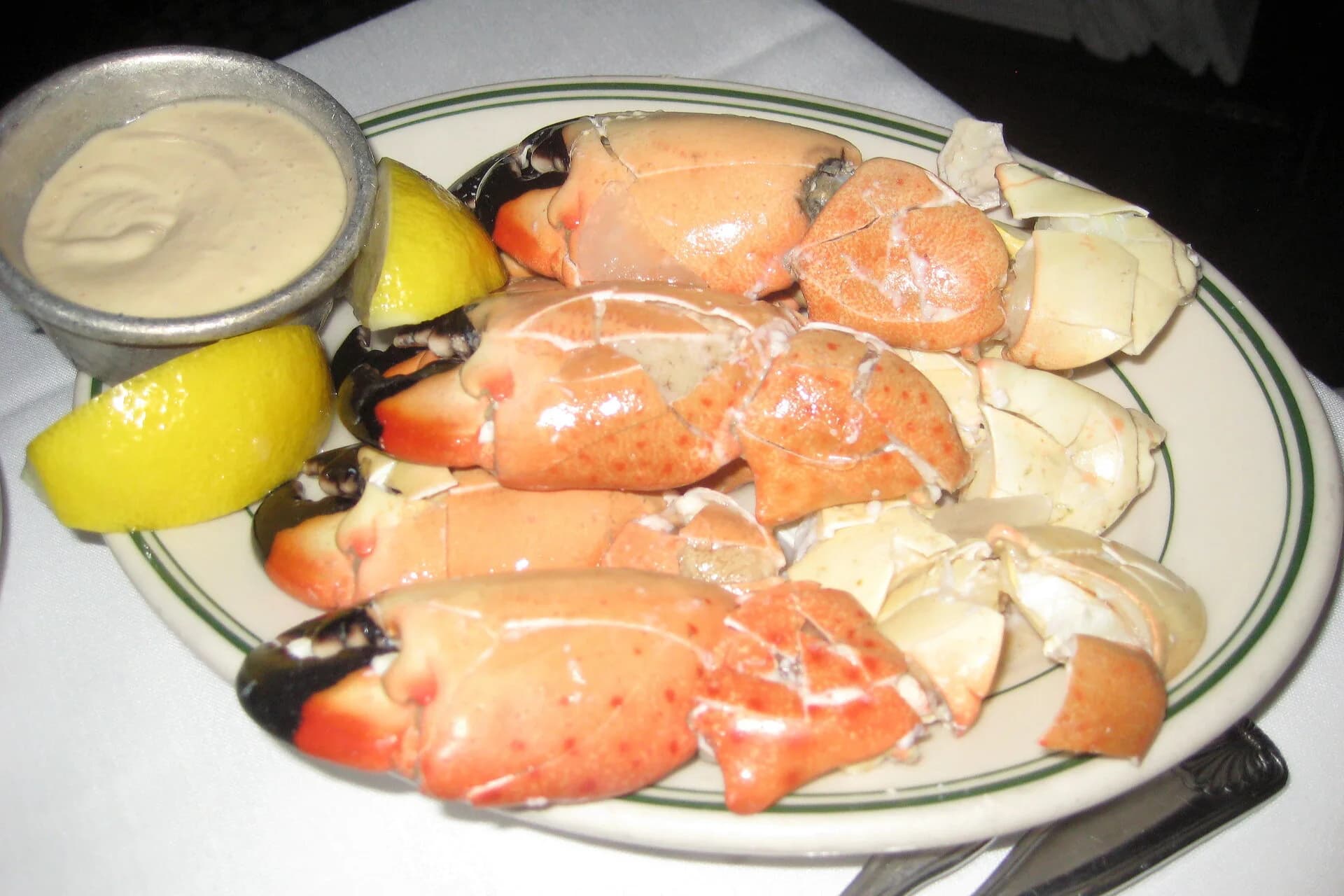 A plate of stone crab claws with lemon and mustard sauce