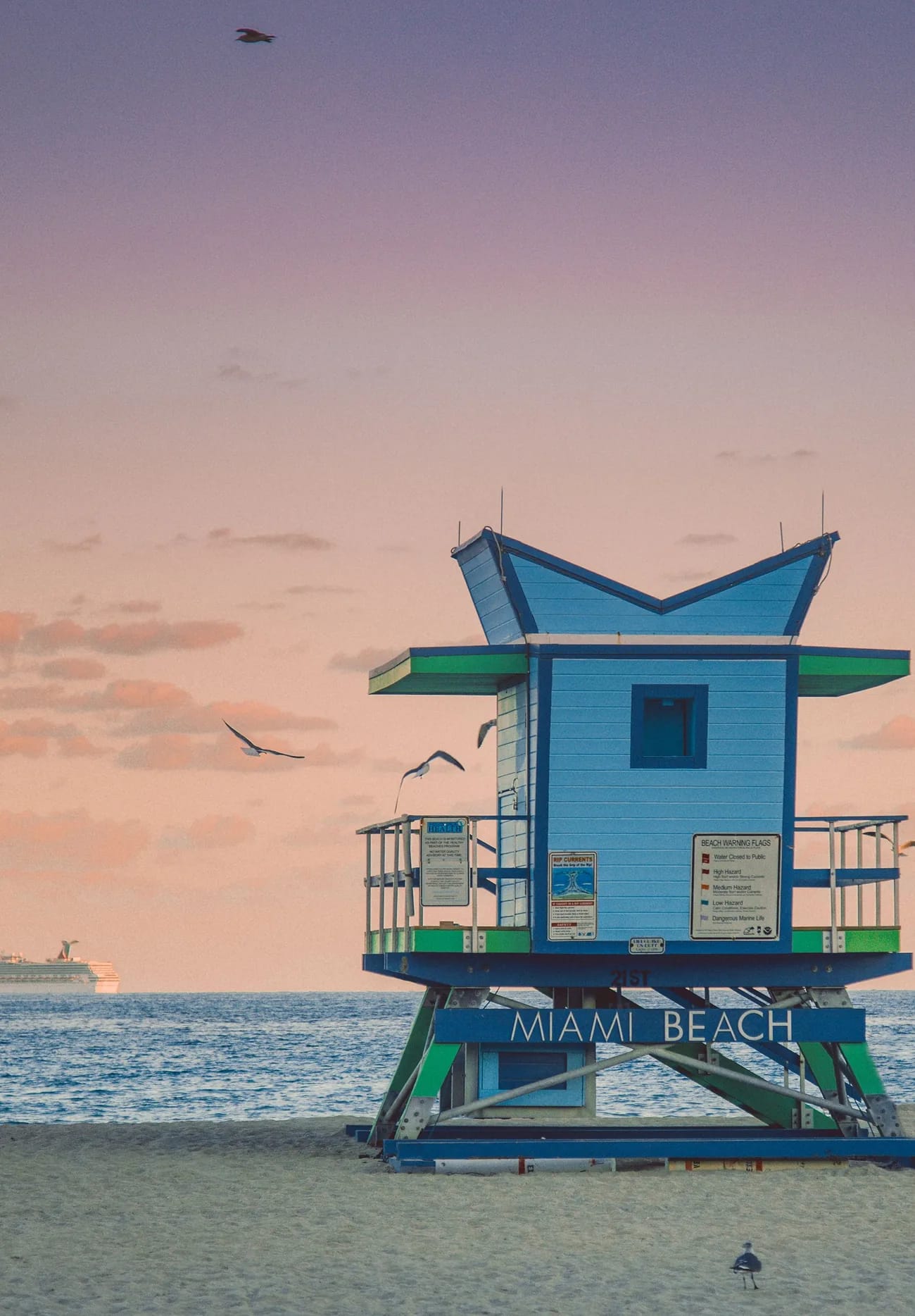 Torre de socorristas azul en la playa de Miami Beach al atardecer rosado